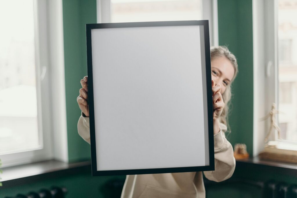 A woman indoors holding a blank photo frame, perfect for mockup or customization. Transforming Employee Insights into Meaningful Actions