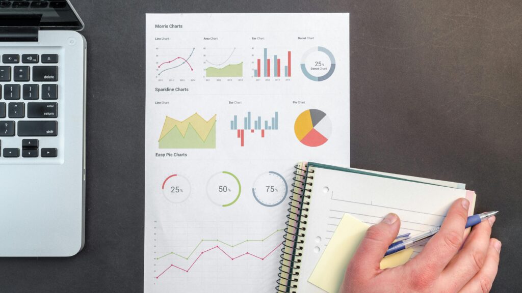 Overhead view of a business desk with charts and a laptop, ideal for data analysis concepts. Transforming Employee Insights into Meaningful Actions